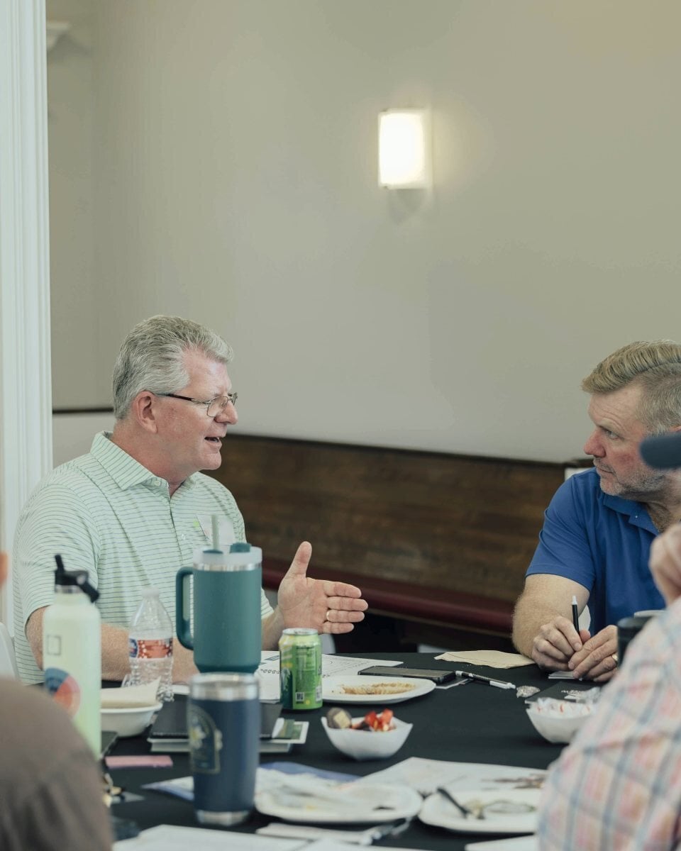 Two men in conversation at a table